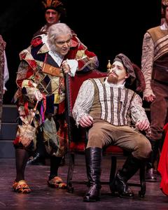 Sitting in a chair as Marullo in Anchorage Opera production of Rigoletto